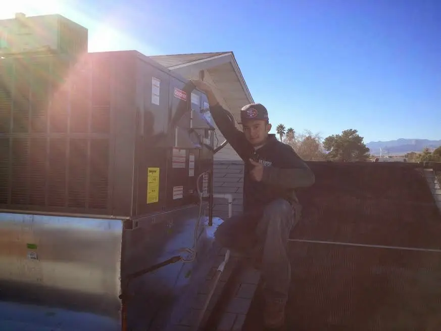 HVAC technician performing AC Tune-Up on a rooftop unit in Mount Hood Villages
