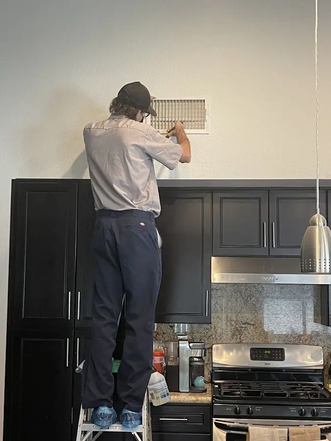 Technician inspecting an air vent during HVAC service in Mount Hood Villages
